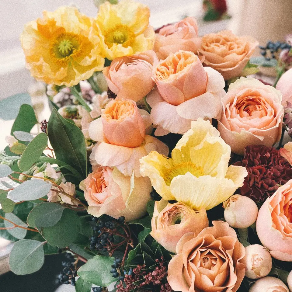 Fleuriste préparant une composition florale sur mesure dans l'atelier de La Tige